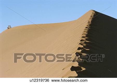 Couple outdoors sitting in the desert (far away) View Large Photo Image Stock Photograph - Couple outdoors sitting in the desert (far away). Fotosearch