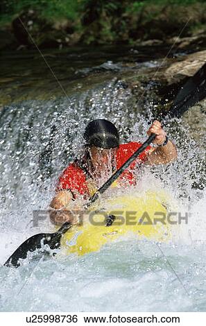 Stock Photograph - Kayaker coming down small waterfall (selective focus). Fotosearch