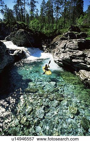 Stock Photo - Kayaker in calm water near waterfall (far away). Fotosearch