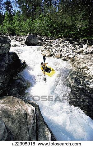 Stock Photo - Kayaker in rapids going over waterfall. Fotosearch