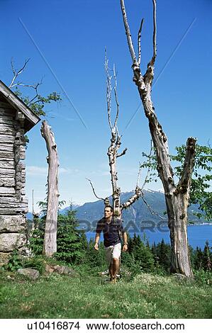 Man outdoors by cabin hiking View Large Photo Image Picture - Man outdoors by cabin hiking. Fotosearch