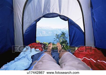 Man's legs in tent overlooking scenic location View Large Photo Image Stock Photo - Man's legs in tent overlooking scenic location. Fotosearch