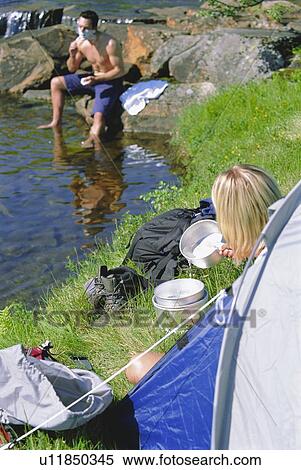 Woman outdoors at campsite with pots with man in background shaving (selective focus) View Large Photo Image Stock Photography - Woman outdoors at campsite with pots with man in background shaving (selective focus). Fotosearch