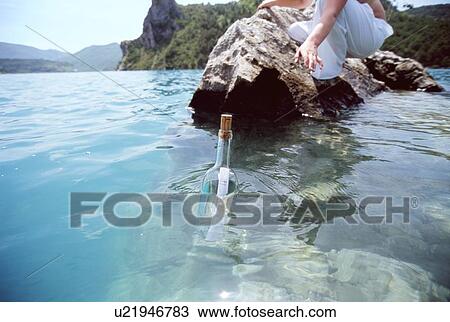 Woman outdoors reaching into ocean for bottle with note inside (selective focus) View Large Photo Image Stock Image - Woman outdoors reaching into ocean for bottle with note inside (selective focus). Fotosearch