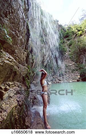 Woman outdoors standing by waterfall (high key) View Large Photo Image Stock Photo - Woman outdoors standing by waterfall (high key). Fotosearch
