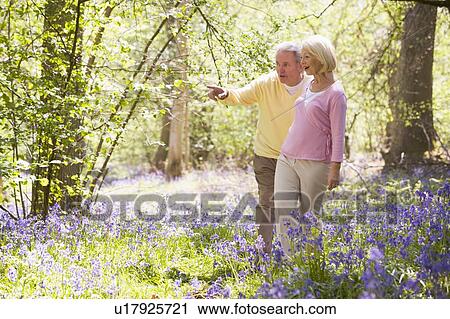 Stock Image - Couple walking outdoors pointing and smiling. Fotosearch
