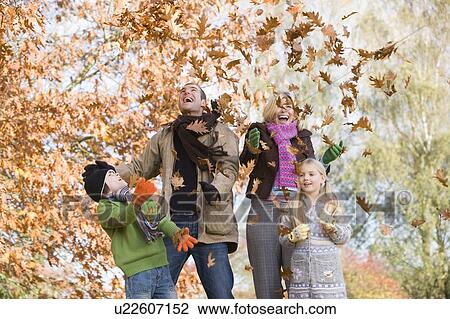 Family outdoors in park playing in leaves and smiling (selective focus) View Large Photo Image Stock Image - Family outdoors in park playing in leaves and smiling (selective focus). Fotosearch
