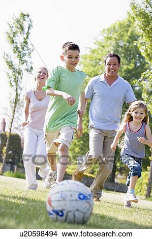 Family outdoors playing soccer and having fun View Large Photo Image Picture - Family outdoors playing soccer and having fun. Fotosearch