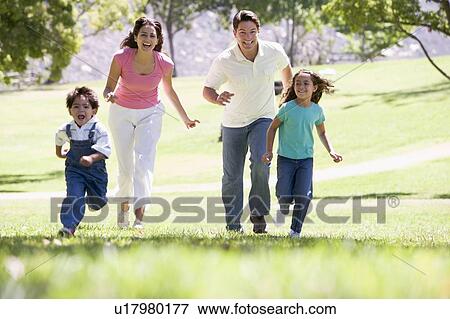 Family running outdoors smiling View Large Photo Image Stock Photo - Family running outdoors smiling. Fotosearch
