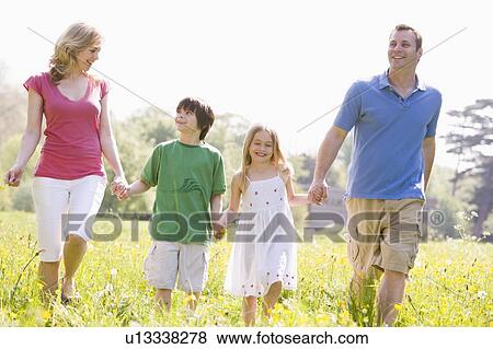 Stock Photo - Family walking outdoors holding flower smiling. Fotosearch