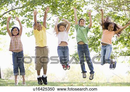 Five young friends jumping outdoors smiling View Large Photo Image Stock Image - Five young friends jumping outdoors smiling. Fotosearch