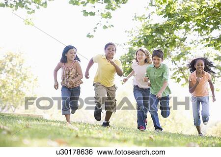 Stock Photograph - Five young friends running outdoors smiling. Fotosearch