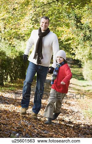 Man and young boy walking outdoors in park and smiling View Large Photo Image Stock Image - Man and young boy walking outdoors in park and smiling. Fotosearch