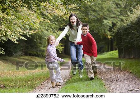 Mother and two young children running on path outdoors (selective focus) View Large Photo Image Stock Image - Mother and two young children running on path outdoors (selective focus). Fotosearch
