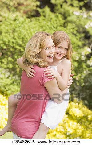 Mother carrying daughter outdoors smiling View Large Photo Image Stock Photography - Mother carrying daughter outdoors smiling. Fotosearch