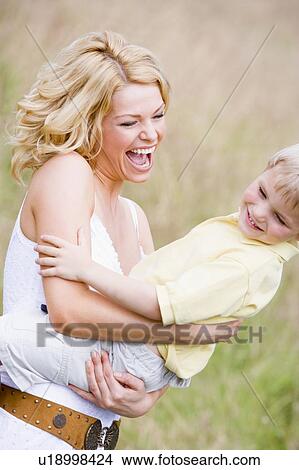 Picture - Mother holding son outdoors smiling. Fotosearch