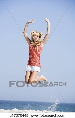 Woman jumping on a beach View Large Photo Image Stock Photography - Woman jumping on a beach. Fotosearch
