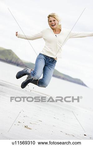 Woman jumping on beach smiling View Large Photo Image Stock Image - Woman jumping on beach smiling. Fotosearch