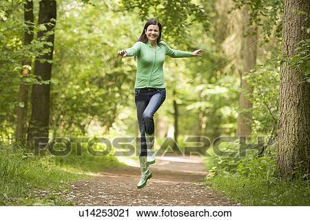 Woman jumping on path smiling View Large Photo Image Stock Image - Woman jumping on path smiling. Fotosearch