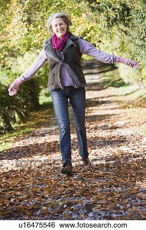 Woman outdoors at park running on path and smiling (selective focus) View Large Photo Image Stock Photograph - Woman outdoors at park running on path and smiling (selective focus). Fotosearch