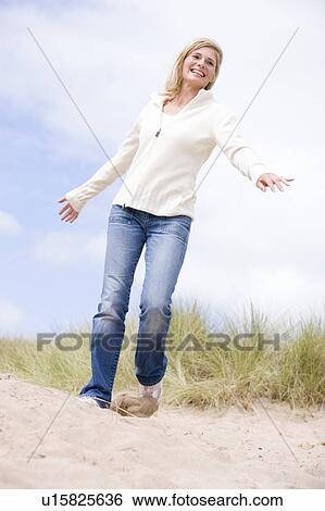 Woman walking on beach smiling View Large Photo Image Stock Photograph - Woman walking on beach smiling. Fotosearch