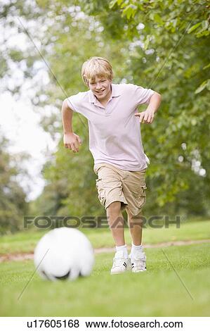 Stock Photo - Young boy playing soccer. Fotosearch
