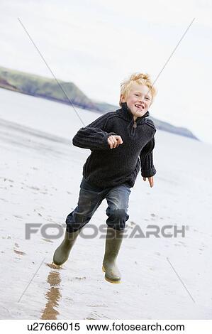 Young boy running on beach smiling View Large Photo Image Stock Photography - Young boy running on beach smiling. Fotosearch