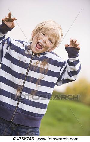 Young boy standing outdoors dirty and smiling View Large Photo Image Stock Photograph - Young boy standing outdoors dirty and smiling. Fotosearch