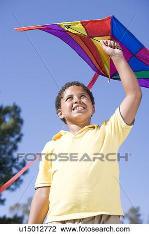 Young boy with kite outdoors smiling View Large Photo Image Stock Image - Young boy with kite outdoors smiling. Fotosearch