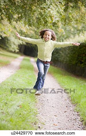Young girl running on a path outdoors smiling View Large Photo Image Stock Image - Young girl running on a path outdoors smiling. Fotosearch