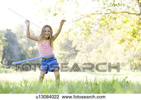 Young girl with hula hoop outdoors smiling View Large Photo Image Stock Image - Young girl with hula hoop outdoors smiling. Fotosearch