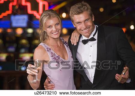 Couple in casino with cigar and champagne smiling (selective focus) View Large Photo Image Stock Image - Couple in casino with cigar and champagne smiling (selective focus). Fotosearch