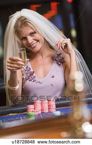 Woman in bridal veil in casino playing roulette and smiling (selective focus) View Large Photo Image Stock Photo - Woman in bridal veil in casino playing roulette and smiling (selective focus). Fotosearch