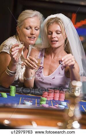 Woman in bridal veil with another woman in casino playing roulette and smiling (selective focus) View Large Photo Image Stock Image - Woman in bridal veil with another woman in casino playing roulette and smiling (selective focus). Fotosearch