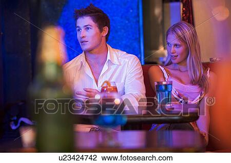 Stock Image - Young couple in a bar. Fotosearch