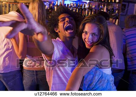 Stock Photograph - Young people dancing in a bar. Fotosearch