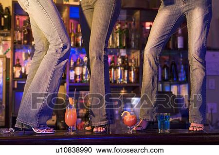 Stock Image - Young people dancing on a bar counter. Fotosearch