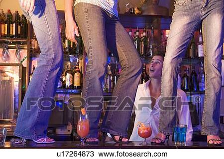 Young people dancing on a bar counter with bartender looking on View Large Photo Image Stock Image - Young people dancing on a bar counter with bartender looking on. Fotosearch