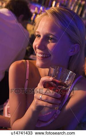 Young woman in a bar View Large Photo Image Stock Image - Young woman in a bar. Fotosearch