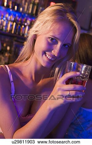 Young woman in a bar View Large Photo Image Stock Image - Young woman in a bar. Fotosearch
