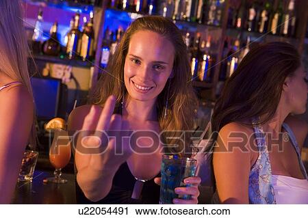 Young woman in a bar with friends View Large Photo Image Stock Image - Young woman in a bar with friends. Fotosearch