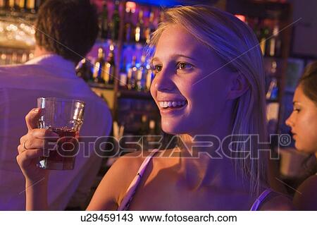 Young woman in a bar with friends View Large Photo Image Stock Image - Young woman in a bar with friends. Fotosearch