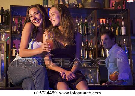 Stock Photo - Young women in a bar. Fotosearch