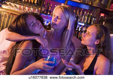 Young women in a bar with one drunk friend passed out View Large Photo Image Stock Photo - Young women in a bar with one drunk friend passed out. Fotosearch