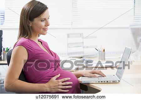 Pregnant woman at work using laptop View Large Photo Image Stock Image - Pregnant woman at work using laptop. Fotosearch