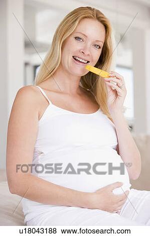 Pregnant woman eating melon slice and smiling View Large Photo Image Stock Photo - Pregnant woman eating melon slice and smiling. Fotosearch