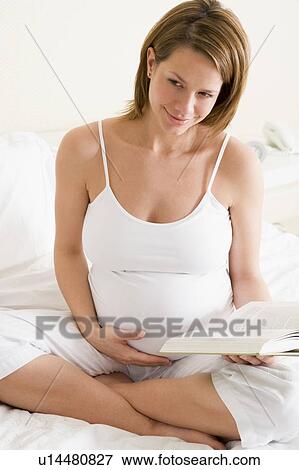 Pregnant woman in bedroom reading book smiling View Large Photo Image Stock Photo - Pregnant woman in bedroom reading book smiling. Fotosearch