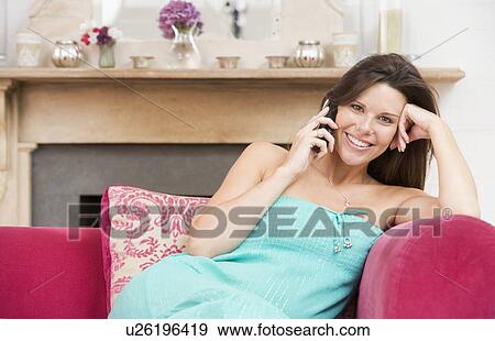Pregnant woman in living room talking on telephone and smiling View Large Photo Image Stock Photo - Pregnant woman in living room talking on telephone and smiling. Fotosearch
