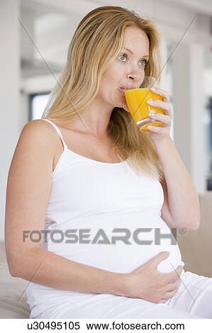 Stock Photography - Pregnant woman with glass of orange juice. Fotosearch