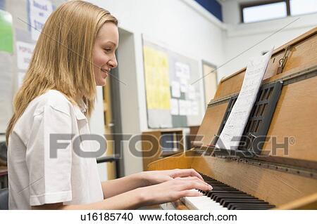 Female student learning piano in classroom View Large Photo Image Stock Image - Female student learning piano in classroom. Fotosearch